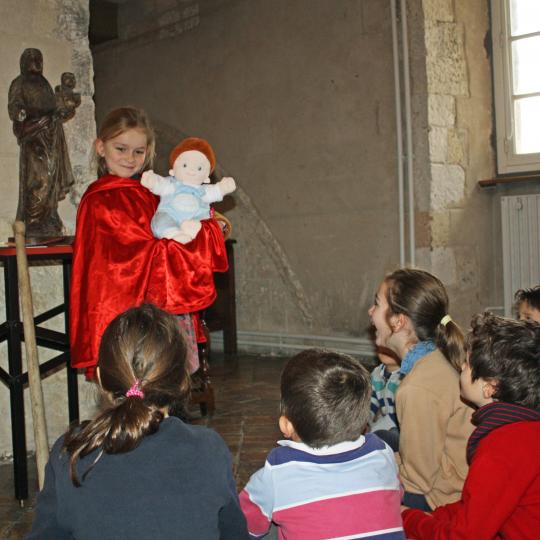 Jeune fille mimant une sculpture de vierge à l'enfant portant le Christ.