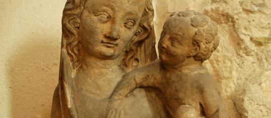 Statuaire en pierre de la Vierge Marie portant l'enfant Jésus.