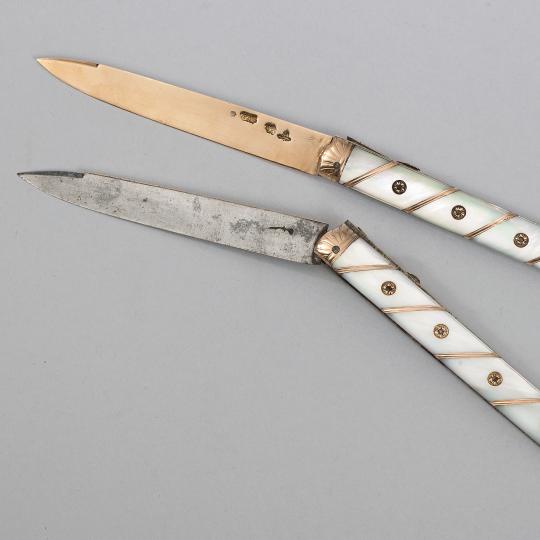 Deux couteaux, dont l'un est présenté légèrement plié.