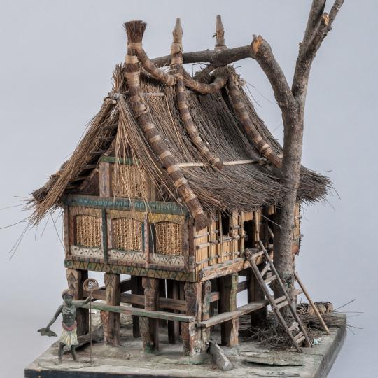 Maison de Java - Maison sur pilotis avec un personnage au pied tenant une épuisette.
