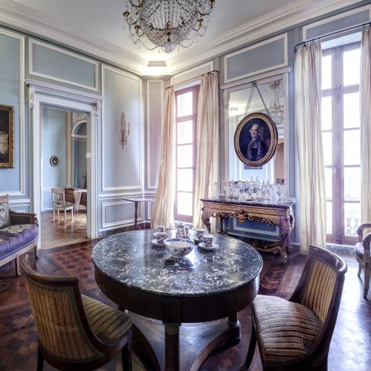 Grand salon présentant un parquet en bois exotique et du mobilier d'époque Empire.