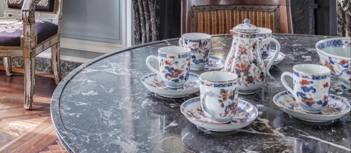 Grand salon de la Maison de l'armateur présentant un service à café en porcelaine.