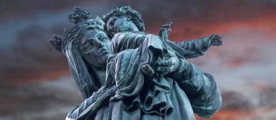 Statue de la Vierge du Havre de Grâce, devant un ciel rose et bleu.