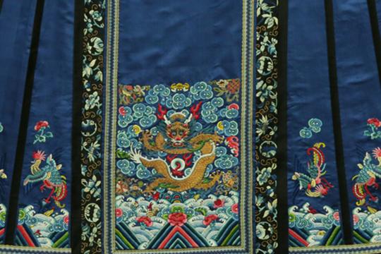 Robe à plis traditionnelle bleue avec motifs représentant un dragon et des phénix. Dynastie Qing.