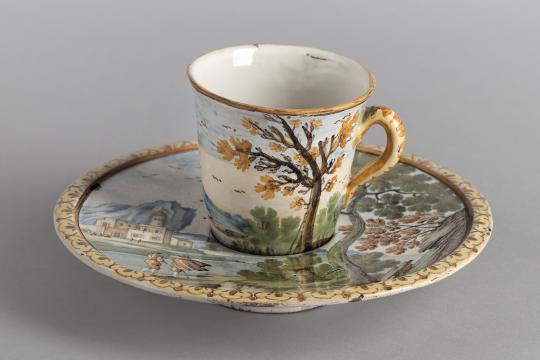 Tasse en faïence avec un décor végétale.