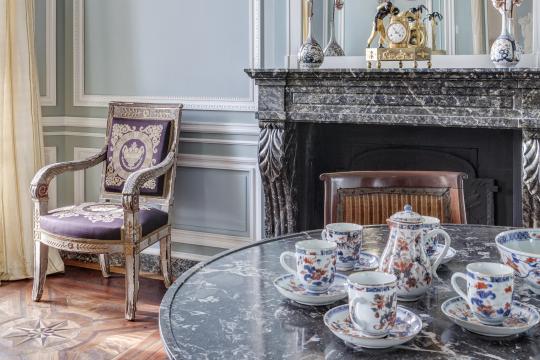 Grand salon de la Maison de l'armateur présentant un service à café en porcelaine.