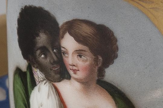 Scène présentant un homme de couleur enlaçant une jeune femme blanche.