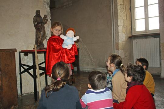 Jeune fille mimant une sculpture de vierge à l'enfant portant le Christ.