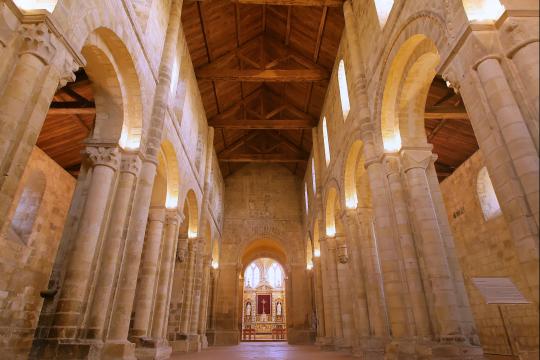 Nef romane de l'abbatiale de Graville, charpente en bois visible et piliers en pierre.