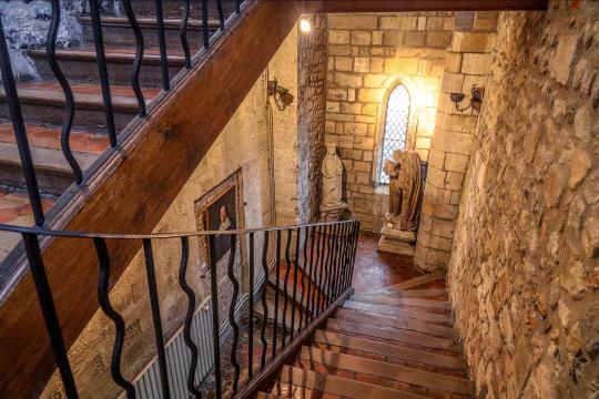 Escalier en tomettes et murs en pierre.