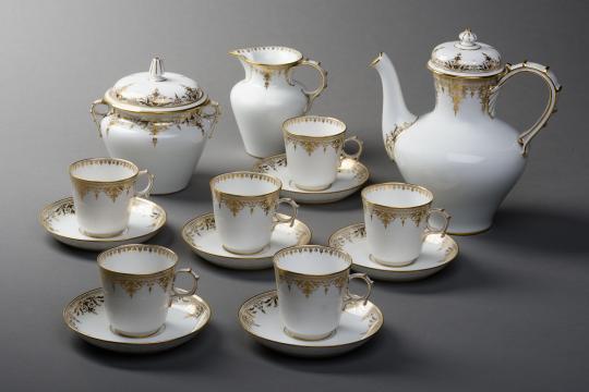 Service à café en porcelaine blanche, composé d'une cafetière, d'un sucrier, d'un pot à lait et de six tasses.