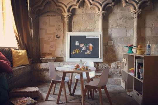 Petite table à dinette, tableau magnétique et tableau à dessins de l'espace enfant.